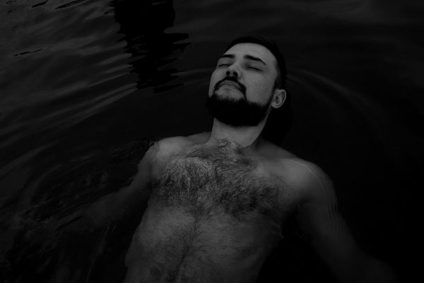 Woman meditating peacefully in a calm, dark environment.